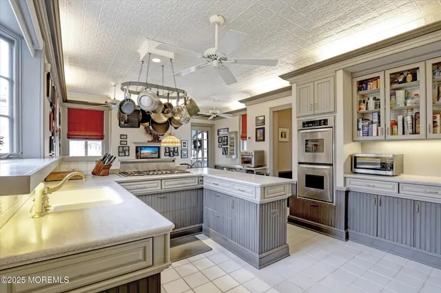 a kitchen with kitchen island granite countertop a sink cabinets and stainless steel appliances