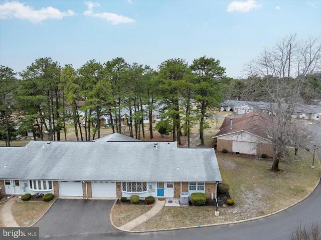 an aerial view of a house with swimming pool and large trees