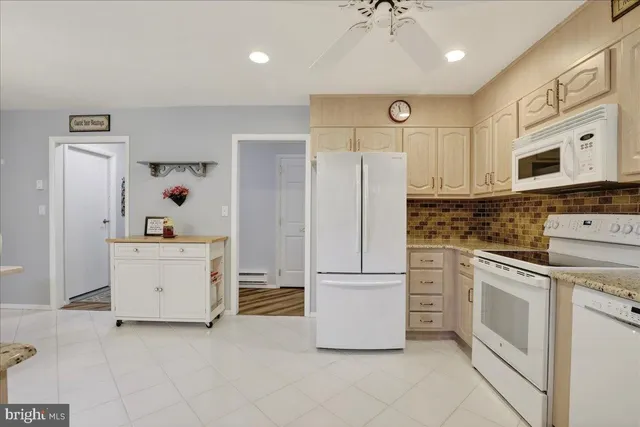 a kitchen with white cabinets and white appliances
