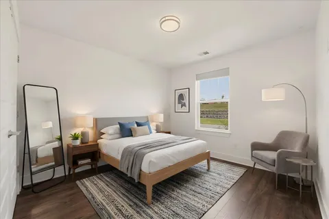 a bedroom with a bed wooden floor and a window