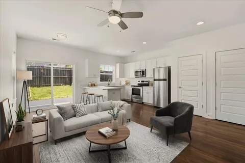 a living room with furniture kitchen view and a window