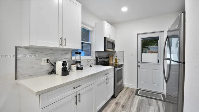 a kitchen with stainless steel appliances a refrigerator sink and cabinets