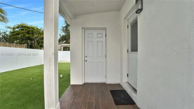 a view of a hallway with wooden floor and a yard