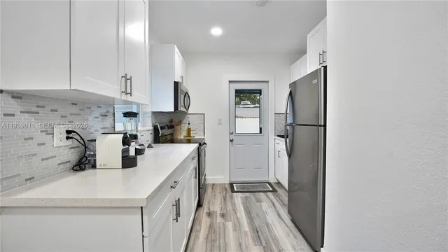 a kitchen with a sink a refrigerator and cabinets