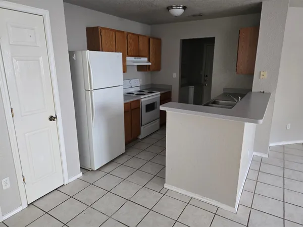 a kitchen with a refrigerator sink and cabinets