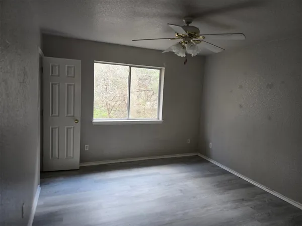 an empty room with windows and fan