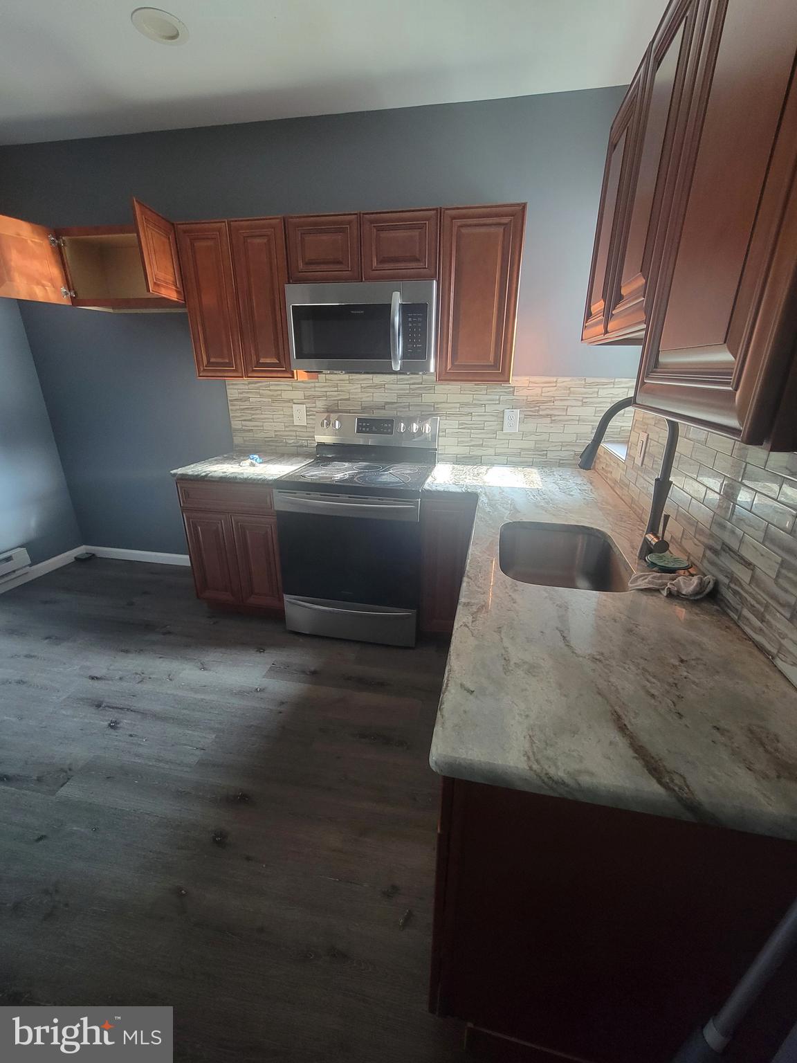 4248 North 7th Street, Unit 2 Philadelphia, PA 19140 - Photo 2 of 6 a kitchen with granite countertop a sink and a stove top oven