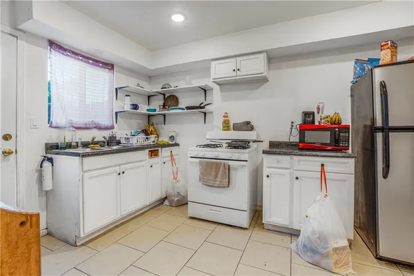 a kitchen with white cabinets and white appliances