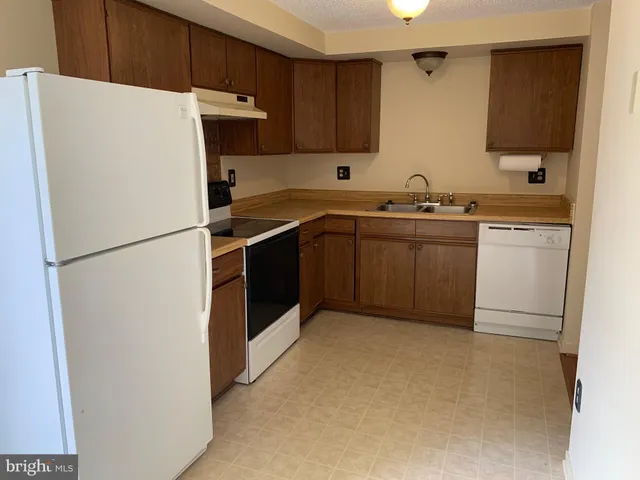 a kitchen with a refrigerator and a sink