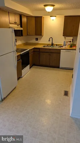 a kitchen with stainless steel appliances a stove a sink and a refrigerator
