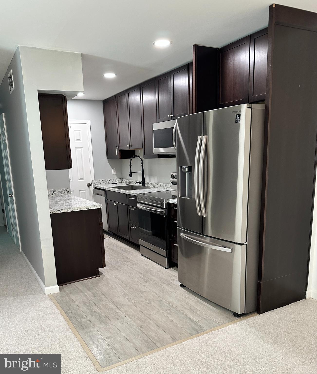 5900 Prince George Drive, Unit 333 Springfield, VA 22152 - Photo 6 of 31 a kitchen with stainless steel appliances granite countertop a refrigerator a sink and wooden cabinets