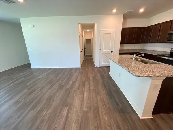 a view of kitchen with wooden floor and cabinets