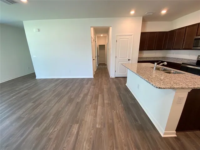 a view of kitchen with wooden floor and cabinets