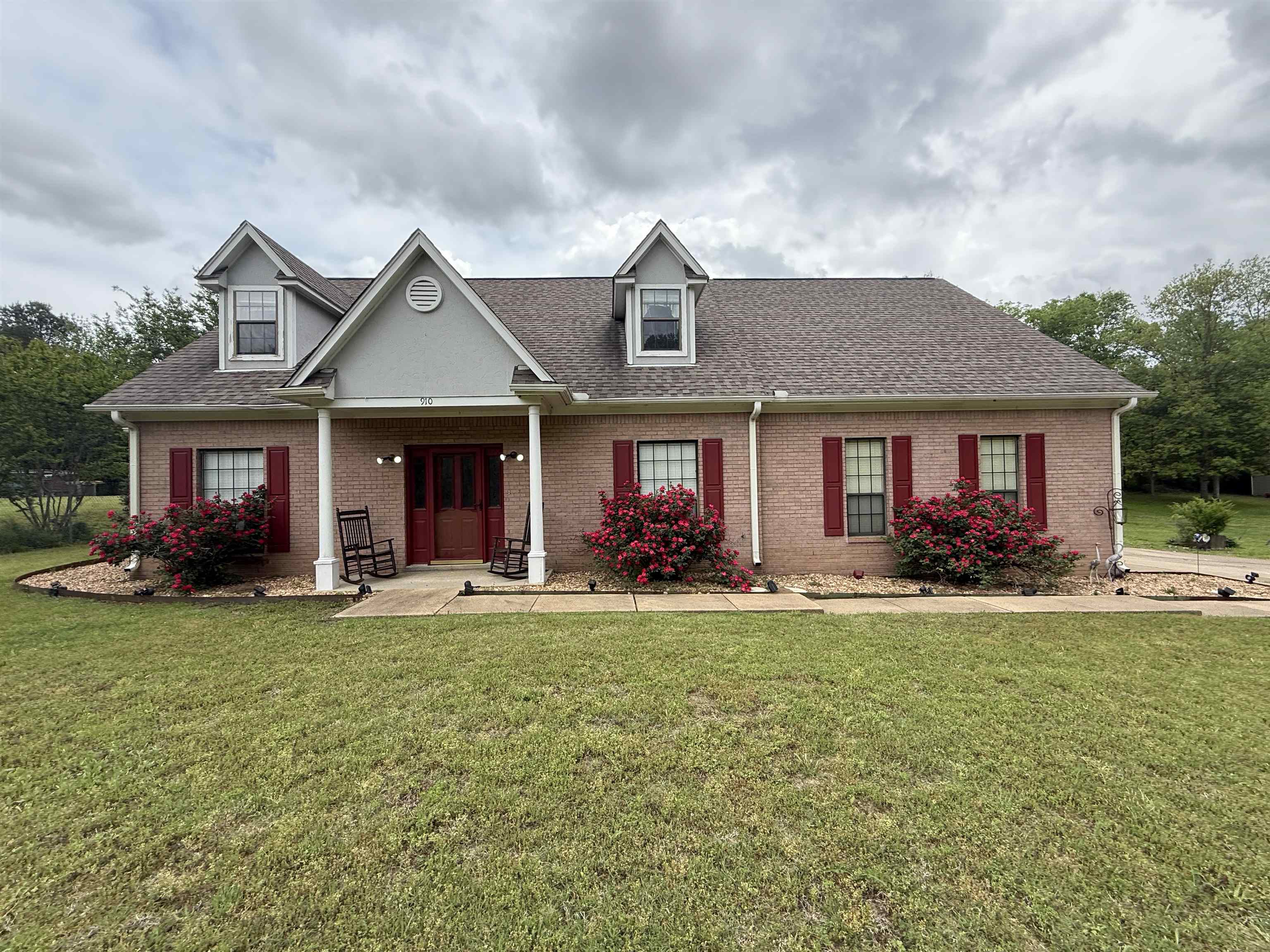 front view of a brick house with a yard