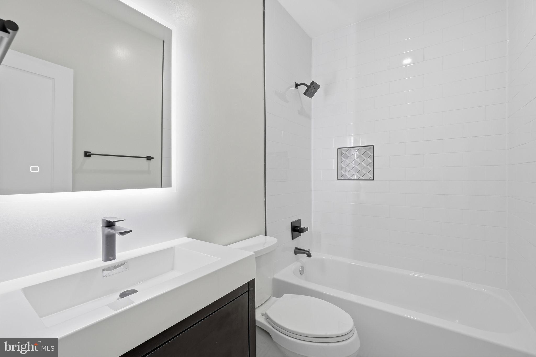 5315 Colorado Avenue Northwest Washington, DC 20011 - Photo 36 of 67 a bathroom with a sink a toilet a mirror a bathtub and shower