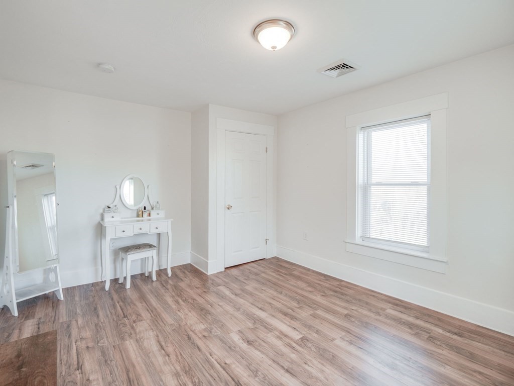 116 Middlesex Road Tyngsborough, MA 01879 - Photo 30 of 42 an empty room with wooden floor white walls and windows