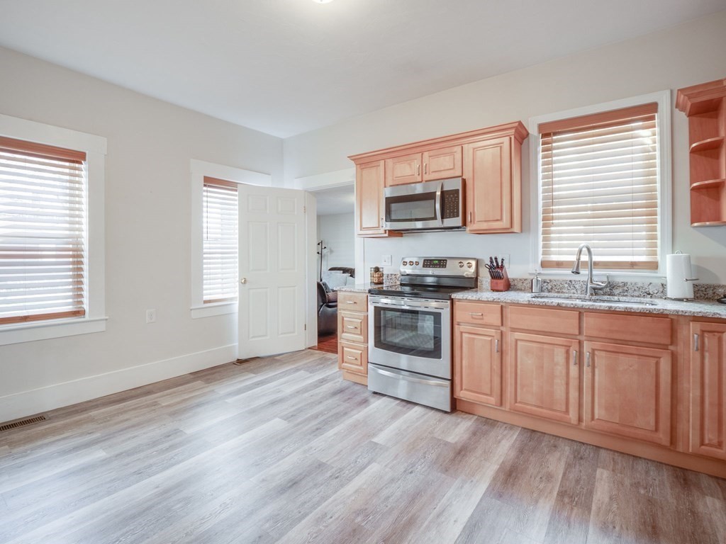 116 Middlesex Road Tyngsborough, MA 01879 - Photo 7 of 42 a kitchen with granite countertop a stove top oven and sink