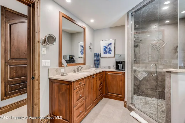 a bathroom with a sink a mirror and a shower