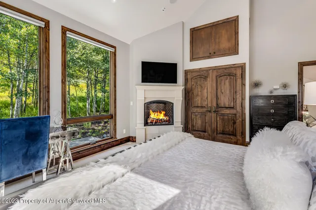 a view of a livingroom with furniture fire place and windows