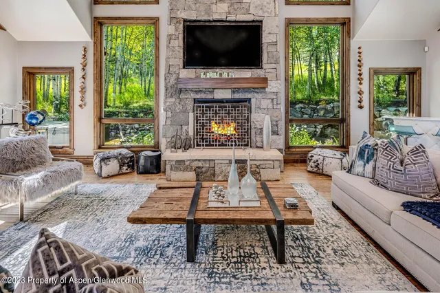 a living room with furniture a flat screen tv and a fireplace