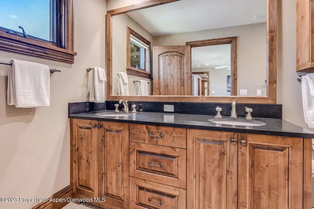 a bathroom with double sink and a mirror