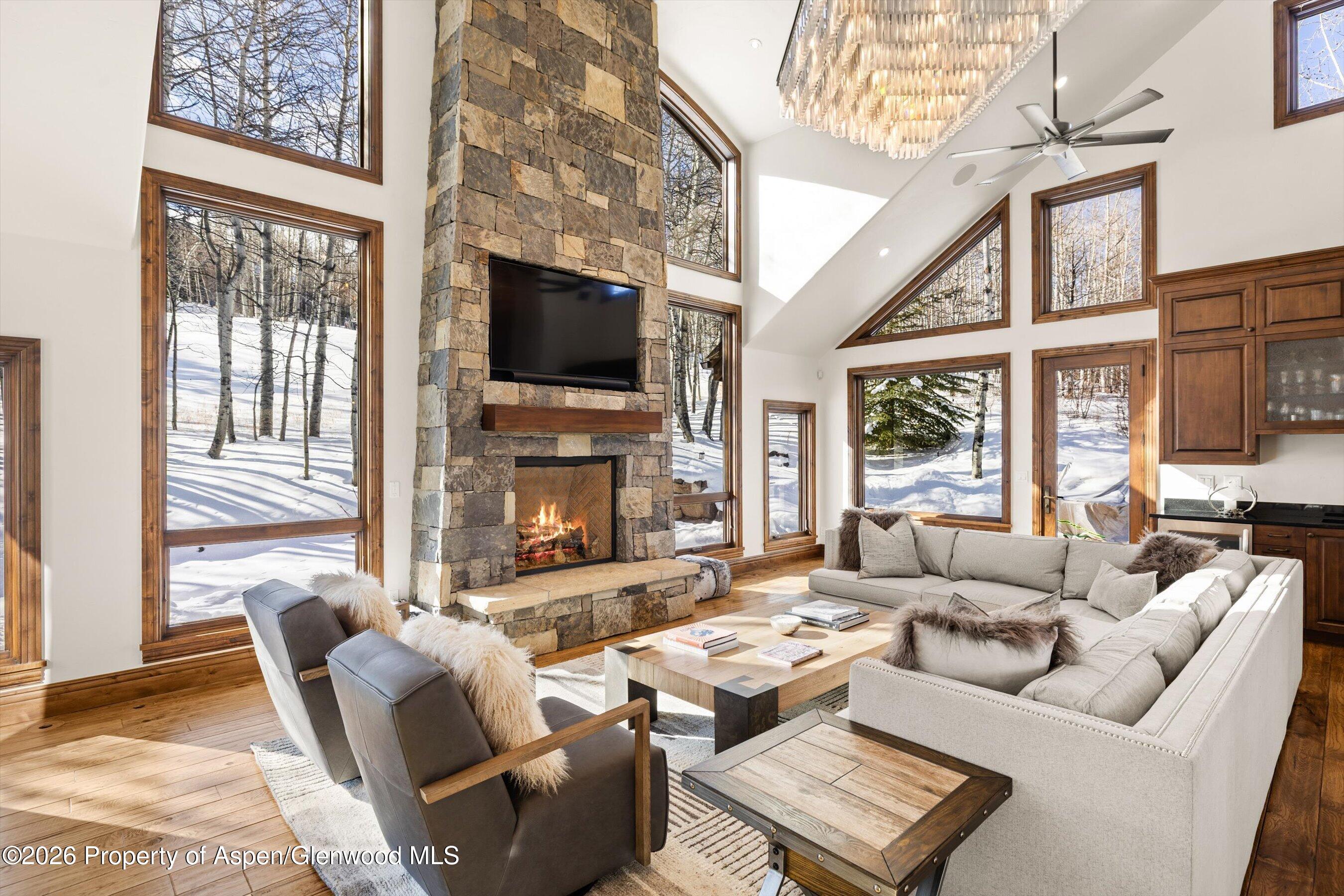 435 Faraway Road Snowmass Village, CO 81615 - Photo 4 of 35 a living room with furniture a flat screen tv and a fireplace