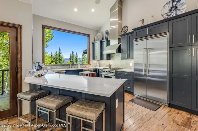 a room with stainless steel appliances kitchen island granite countertop furniture and a refrigerator