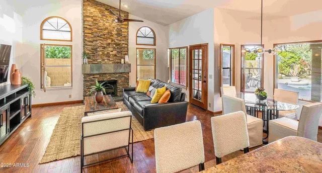 a living room with furniture a flat screen tv and a floor to ceiling window