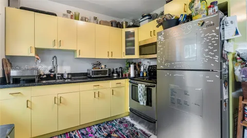 a kitchen with stainless steel appliances granite countertop a refrigerator a stove and a sink with wooden floor