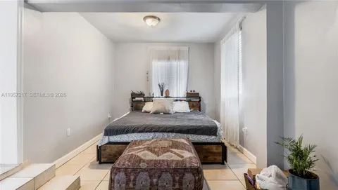 a bed room with a bed and a potted plant