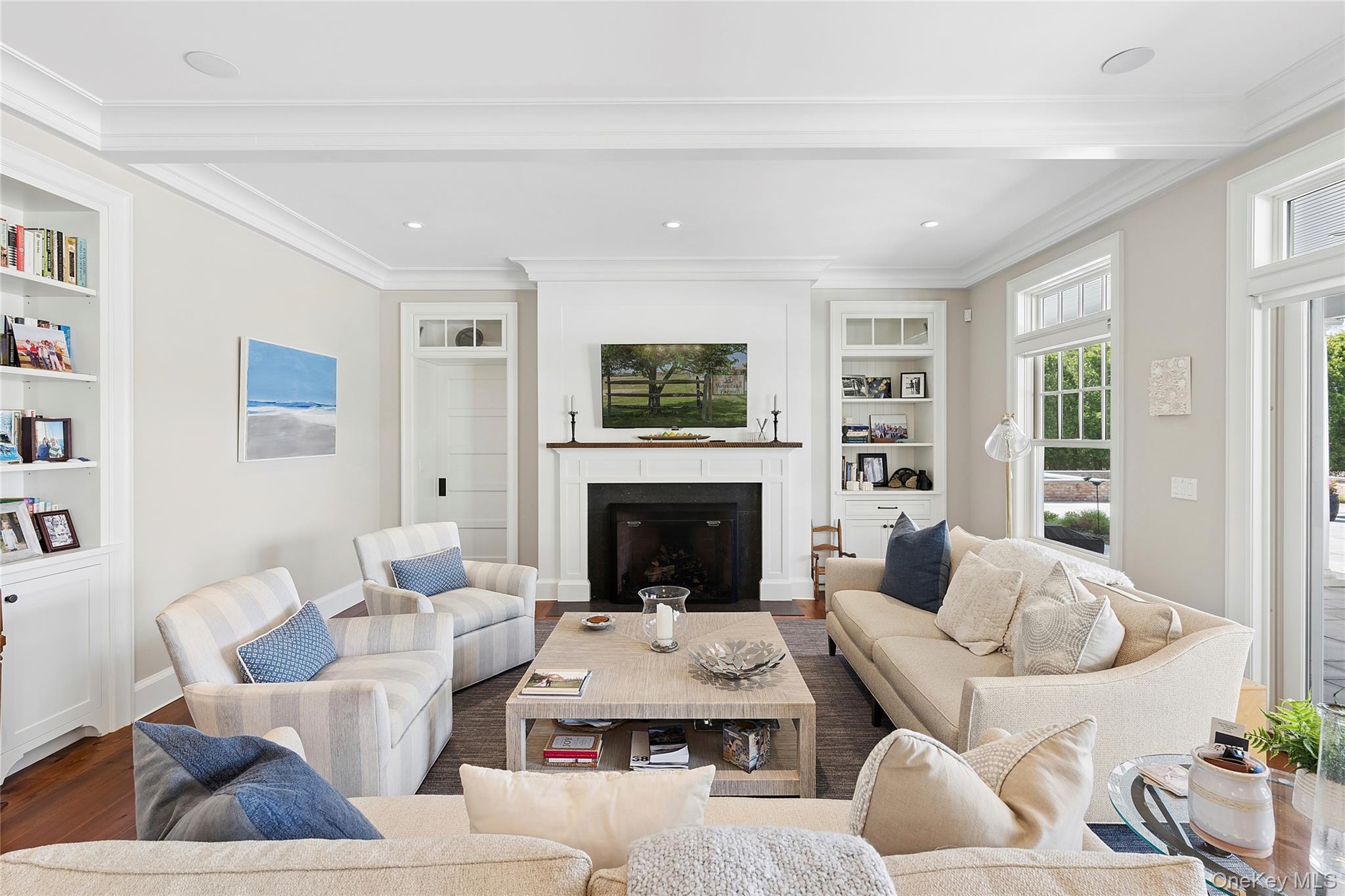 43 Old Main Road Quogue, NY 11959 - Photo 11 of 28 a living room with furniture a fireplace and a large window