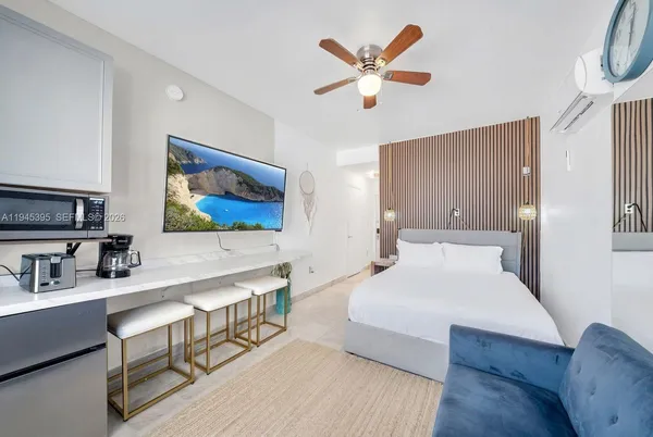 a bedroom with a large bed a rug and a chandelier