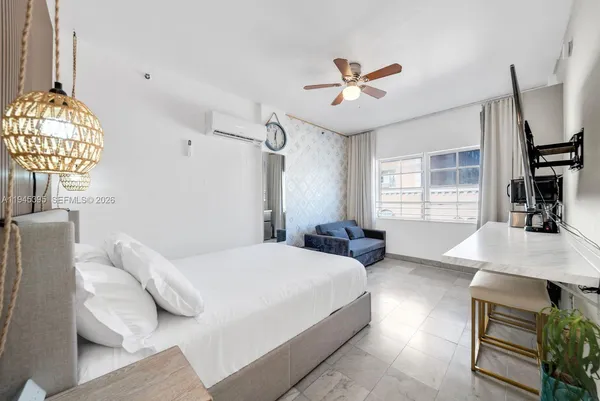 a bedroom with a bed mirror and window