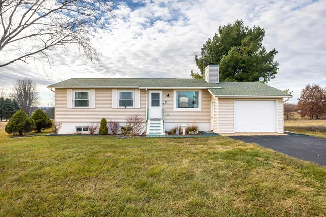 a house that has a big tree in front of a house