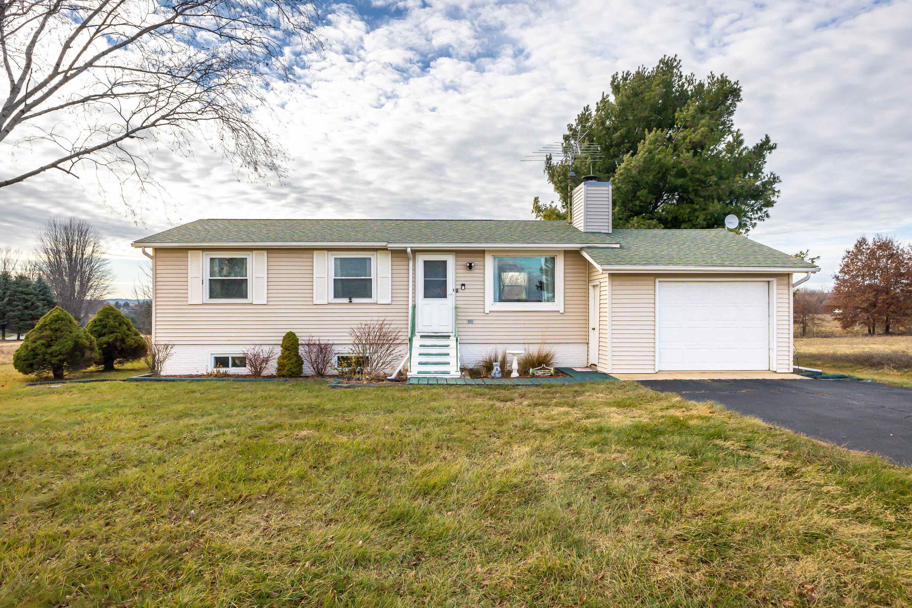 a house that has a big tree in front of a house