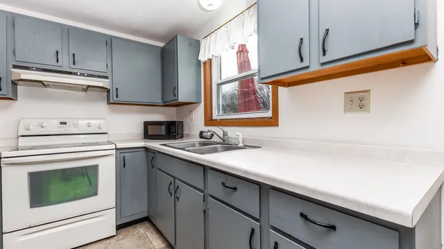 a kitchen with a sink cabinets and window