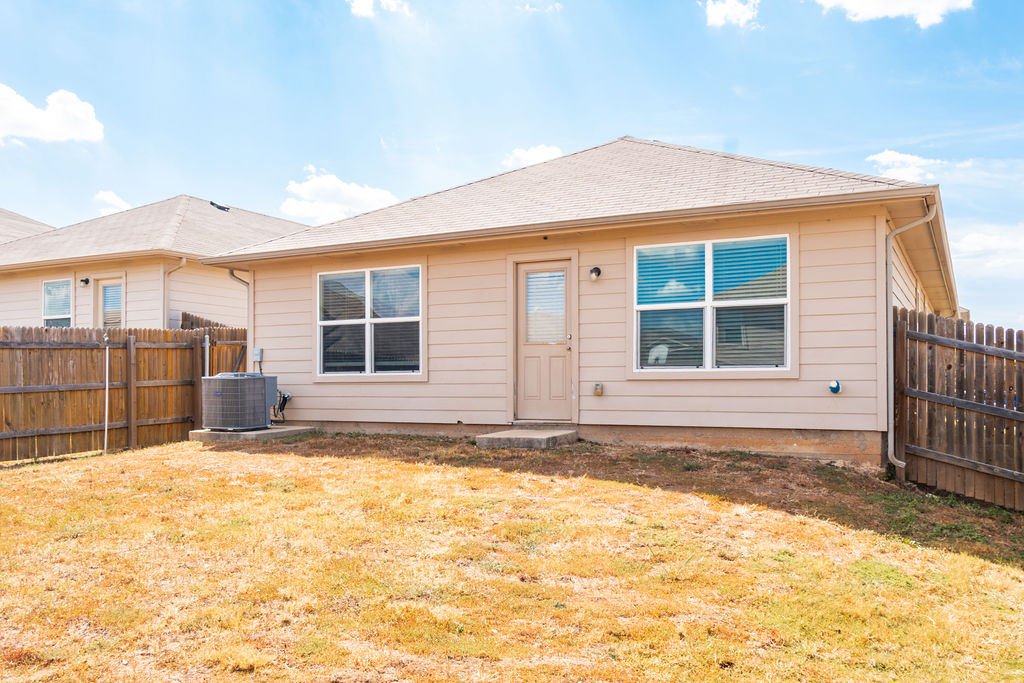 14915 Talus Road Manor, TX 78653 - Photo 15 of 20 Sloping lawn leads to a classic wood-sided exterior under a shingle roof.