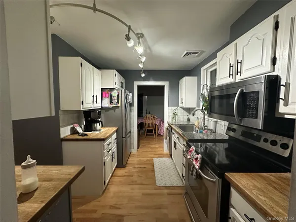 a kitchen with stainless steel appliances kitchen island granite countertop a sink stove and cabinets