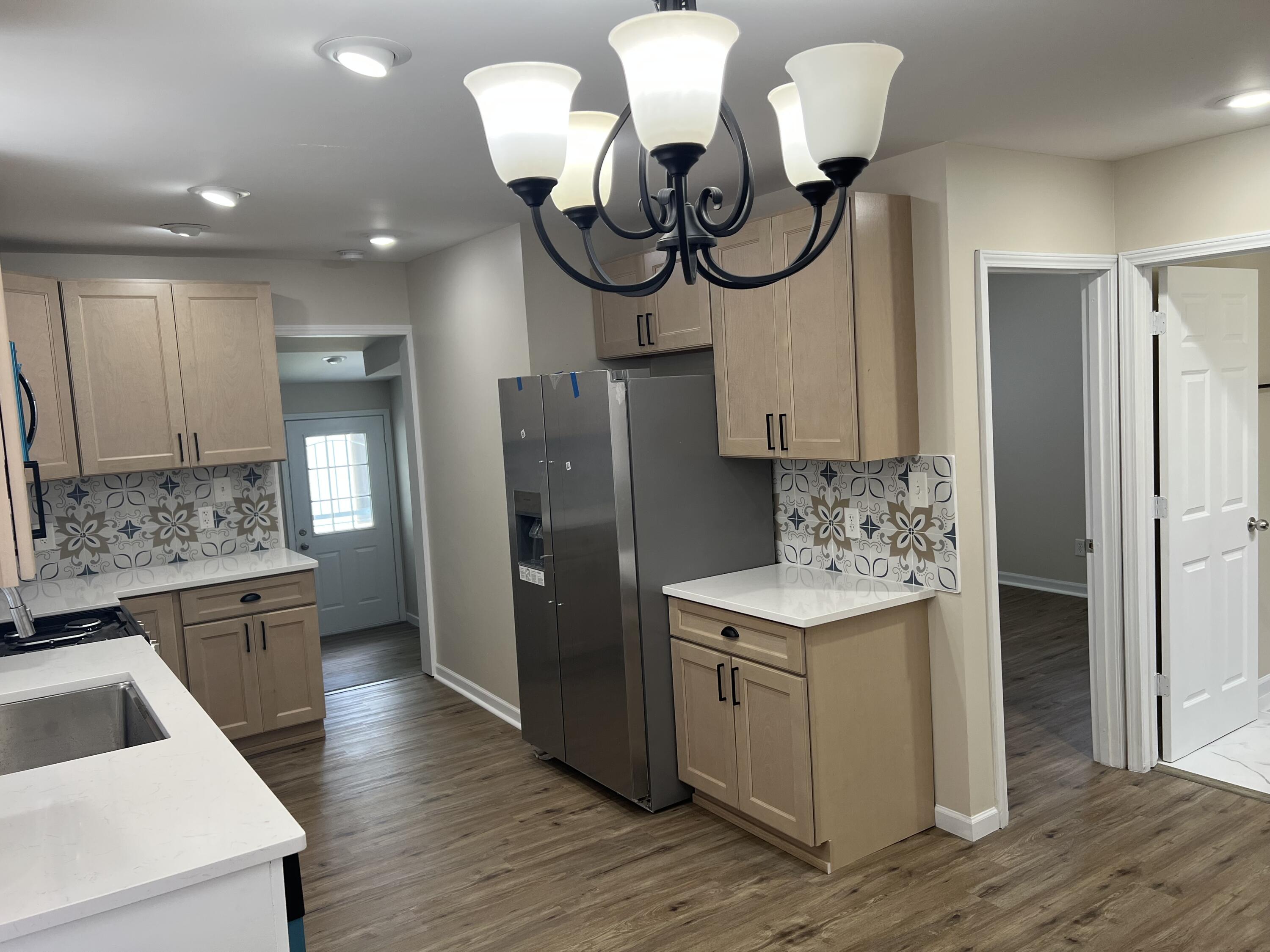 3851 Maple Street Hobart, IN 46342 - Photo 5 of 28 a kitchen with stainless steel appliances granite countertop a refrigerator a sink dishwasher and white cabinets with wooden floor