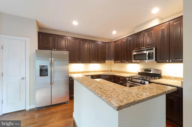 a kitchen with granite countertop a stove a sink and a microwave