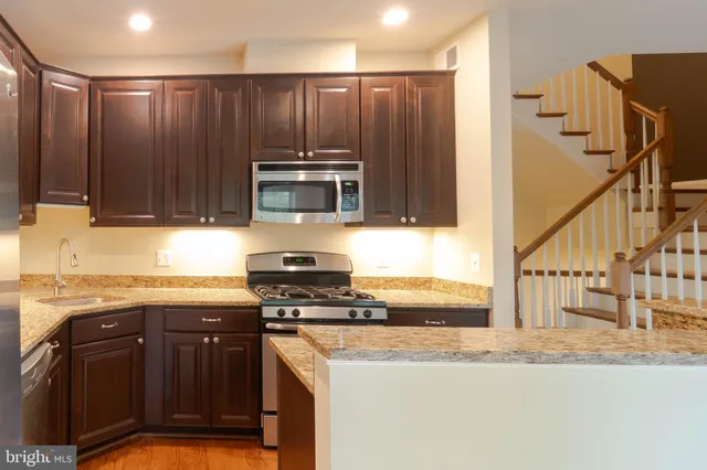 a kitchen with granite countertop a sink and a stove