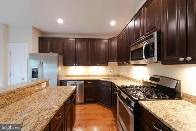 a kitchen with granite countertop sink and cabinets
