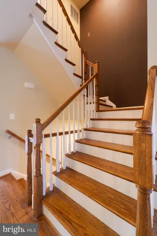 a view of a hallway with bathroom and wooden floor