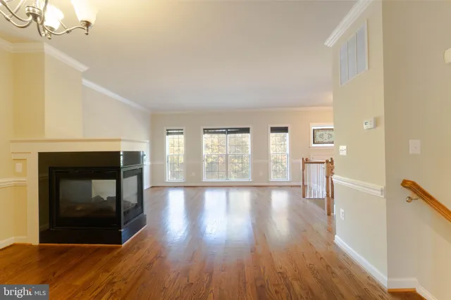 a view of a livingroom with wooden floor and a fireplace