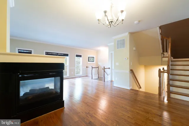 a living room with a fireplace and wooden floor