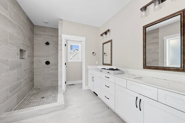 a bathroom with a granite countertop sink mirror and shower