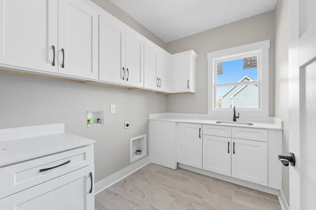 a kitchen with white cabinets appliances and a sink