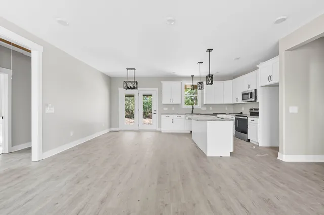 a view of kitchen with cabinets appliances and wooden floor