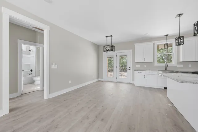 a view of a kitchen with a sink and dishwasher with wooden floor