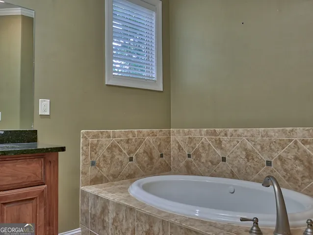 a bath tub sitting in a bathroom next to a sink
